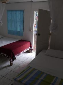 Habitación con cama y puerta con ventana en Luna International Hostel en Estelí