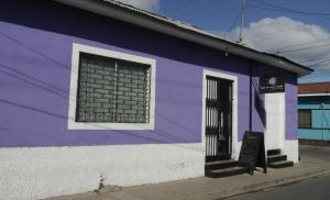 un edificio blanco y púrpura con ventana en Luna International Hostel, en Estelí