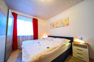 a bedroom with a bed and a dresser and a window at Privatzimmer Haus Erika in Sankt Peter-Freienstein