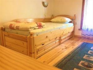 Cama de madera en un dormitorio con suelo de madera en "Tipografov" Guest House, en Veliko Tŭrnovo