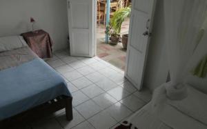 1 dormitorio con 1 cama y puerta abierta en Luna International Hostel, en Estelí