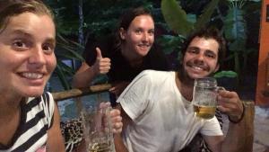 un groupe de trois personnes tenant un verre de bière dans l'établissement Hotel Chaac Calakmul, à Xpujil