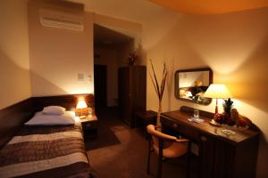a bedroom with a bed and a desk with a mirror at Hotel Wit Stwosz in Krakow
