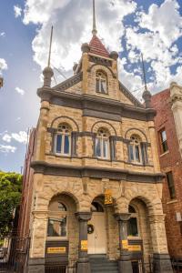 um velho edifício de tijolos com uma torre no topo em Fremantle Bed & Breakfast em Fremantle