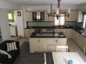 a kitchen with white cabinets and a black counter top at vraxleri house in Kassiopi