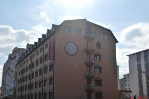 un bâtiment avec une horloge sur son côté dans l'établissement Arion Hotel, à Constanţa