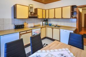 a kitchen with yellow cabinets and a table and chairs at Privatzimmer Haus Erika in Sankt Peter-Freienstein