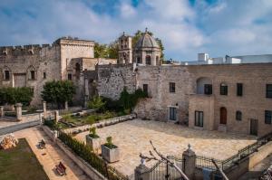 un vecchio edificio in pietra con una torre sullo sfondo di GH Dimora Sant'Anna a Carovigno