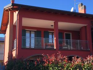una casa roja con un balcón en el lateral. en Casa Dany, en Lugagnano