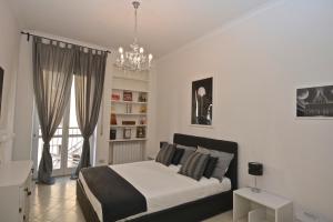 sypialnia z łóżkiem i żyrandolem w obiekcie House & The City - Apartments in Rome w Rzymie