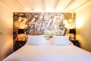 เตียงในห้องที่ Hôtel Au Logis des Remparts