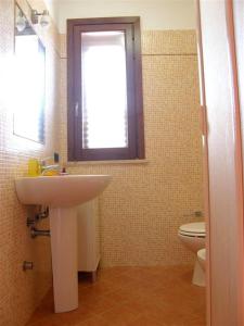 サン・ヴィート・ロ・カーポにあるBluvacanze Appartamento Matteo P1°のバスルーム(洗面台、トイレ付)、窓が備わります。