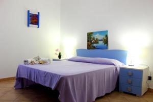 サン・ヴィート・ロ・カーポにあるBluvacanze Appartamento Matteo P1°のベッドルーム1室(紫色のベッドカバー付)