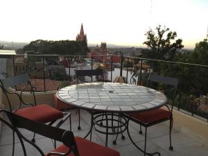 a table and chairs on a balcony with a view at Casa del Tio Hotel Boutique in San Miguel de Allende