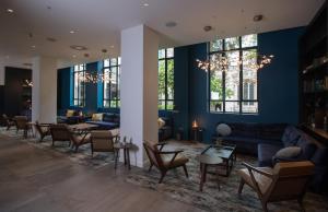 a living room with blue walls and couches and tables at Apex City Of London Hotel in London