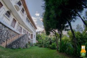 una casa con un prato accanto a un edificio di El Balcón de Ataco a Concepción de Ataco