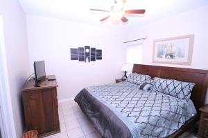 Un dormitorio con una cama y un ventilador de techo. en Los Cabos III Condominiums, en South Padre Island
