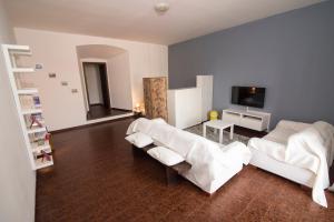 a living room with white furniture and a flat screen tv at Il Castello Delle Meraviglie in Fontaneto dʼAgogna