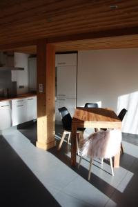モルジヌにあるLe 995のキッチン(木製テーブル、椅子2脚付)