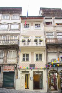 un edificio alto con banderas delante en Laurear Guest House, en Oporto