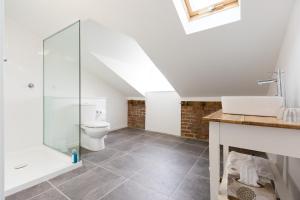 a bathroom with a toilet and a glass shower stall at Ratho Farm in Bothwell