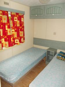 a room with two beds in a room with presents on the wall at Camping la Tour in Embrun