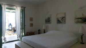 a bedroom with a white bed and a large window at Villa Martha in Kea in Koundouros