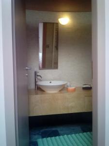 W łazience znajduje się umywalka i lustro. w obiekcie Villa Anastasia w mieście Krousón
