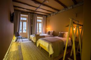 una camera d'albergo con due letti e una sedia di Laurear Guest House a Porto