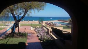 a view of a park with a tree and the ocean at La Perla del Mare in Castelsardo