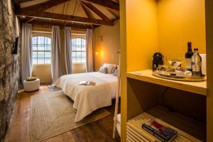 a bedroom with a bed, table and a window at Laurear Guest House in Porto