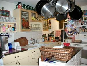 una cocina con ollas y sartenes colgadas sobre un fregadero en A Meadow House, en Lakeville