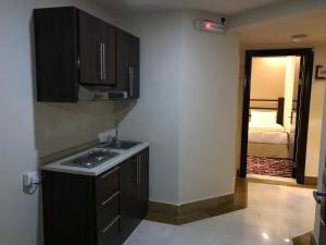 a kitchen with a sink and a stove in a room at Al JAWHRA TOWER HOTEL in Mecca