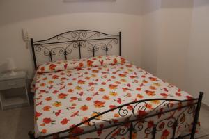 トッレ・スーダにあるCase Vacanza Rossellaの花柄の掛け布団付きのベッド