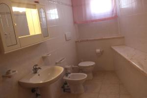 トッレ・スーダにあるCase Vacanza Rossellaの白いバスルーム(洗面台、トイレ付)