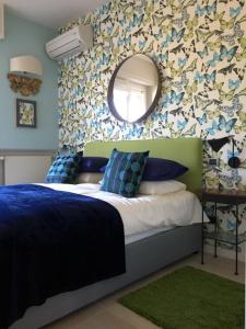 Un dormitorio con una cama con un espejo en la pared. en Clorofilla, en Desenzano del Garda