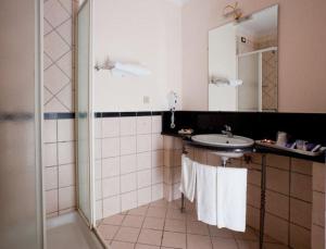 a bathroom with a sink and a shower with towels at Hermitage Capua Hotel in Capua