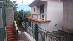 a white house with a balcony and stairs at Vila Pragelas in Santa Cruz