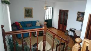 a living room with a blue couch and a staircase at Vila Pragelas in Santa Cruz