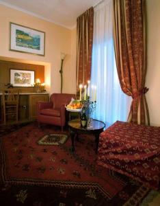 uma sala de estar com uma cama e uma mesa com velas em Hermitage Capua Hotel em Capua