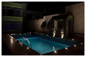 basen w nocy z oświetleniem wokół niego w obiekcie Sueños del Valle w mieście Sangolquí