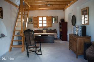 a room with a ladder and a bed and a chair at Siskosplace in Oia