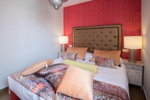 1 dormitorio con 1 cama grande y pared roja en Alhambra Boutique Apartments by TAM Resorts, en Playa del Inglés