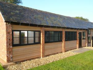 a large wooden garage with a pitched roof at White House Farm Cottages in West Haddon
