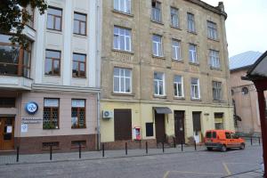 an orange van parked in front of a building at Apartment on Ploshcha Svyatogo Teodora in Lviv