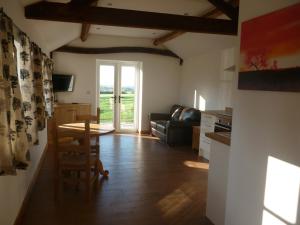 a living room with a table and a couch at White House Farm Cottages in West Haddon +26 photos