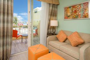 a living room with a couch and a balcony at Holiday Inn Express & Suites Nassau by IHG in Nassau
