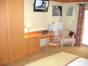 ein Schlafzimmer mit Schreibtisch, Stuhl und Fernseher in der Unterkunft Landgasthof Schweizerhof in Wonneberg