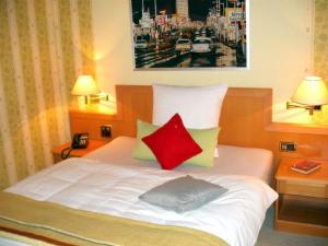 ein Schlafzimmer mit einem weißen Bett mit zwei roten Kissen in der Unterkunft Landgasthof Schweizerhof in Wonneberg + 28 Fotos