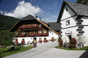 un grande edificio bianco con fioriere sopra di Ferienwohnungen Pfeifenberger-Schieferbauer a Zederhaus